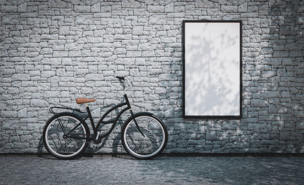 一张空白的海报模板贴在一堵石墙上，旁边是一辆经典的荷兰自行车图片下载