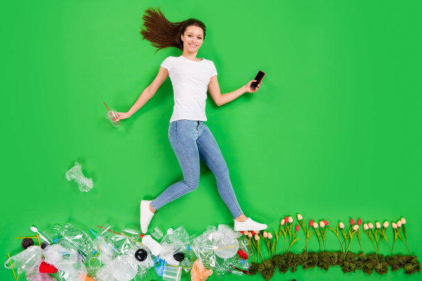 全尺寸高角度平躺照片不负责任的市民女士扔塑料产品乱扔街道地球污染踩花心灵只有电话孤立的绿色背景图片下载