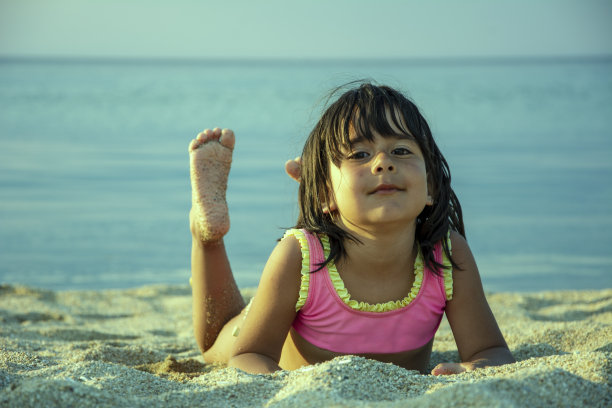 小女孩躺在沙滩上图片下载