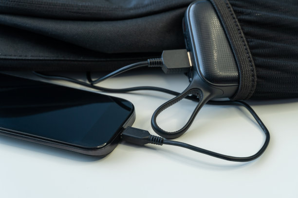 白色木板上的背包里装着充电的智能手机图片下载