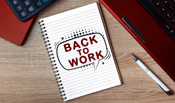 带文本的笔记本返回工作。桌上有笔记本和一支笔。图片下载