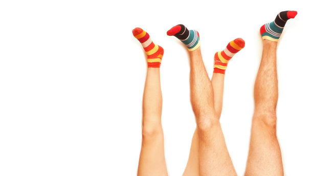有趣的条纹袜子。已婚夫妇的腿。孤立在白色上。图片下载