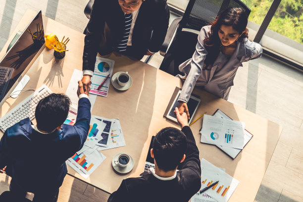 团队商务人员在会议桌上握手图片下载