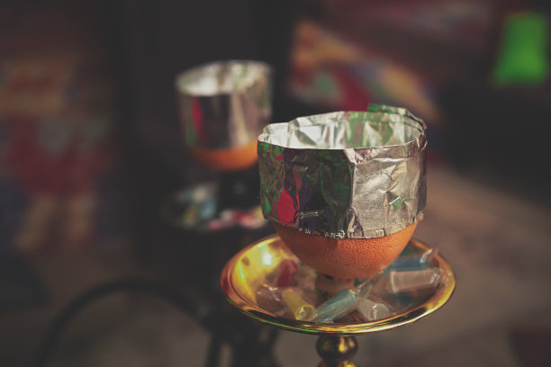 水烟与调味烟草在橙色水果碗覆盖箔节省线圈热量。图片下载