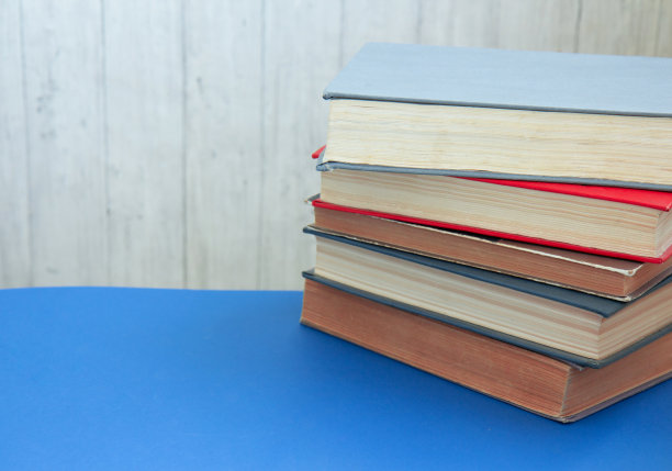 旧的和很好的使用精装书。许多书成堆。精装书在蓝色桌侧视图。回到学校图片下载