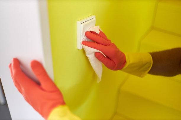 一名男子戴着橡胶手套用消毒湿巾消毒和清洁电灯开关的各种照片图片下载