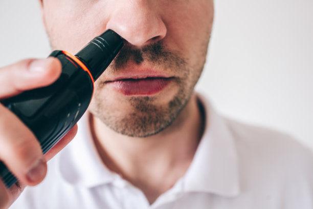 年轻人被孤立在白色背景下。近距离和剪视图的家伙从他的鼻子与修剪头发。精确细致的工作。图片下载