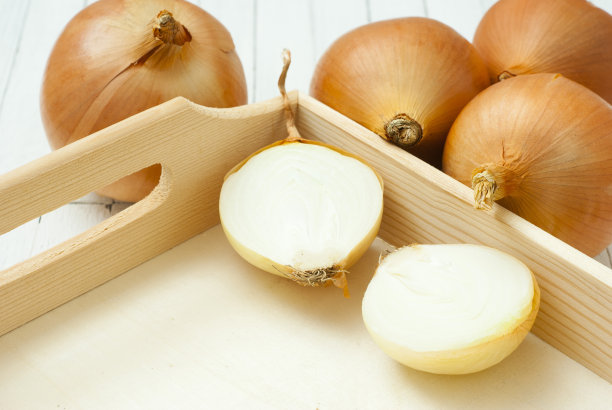洋葱放在白色的木桌上图片下载