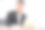 一位亚洲商人穿着黑色西装坐在办公室里，看着镜头。图片下载
