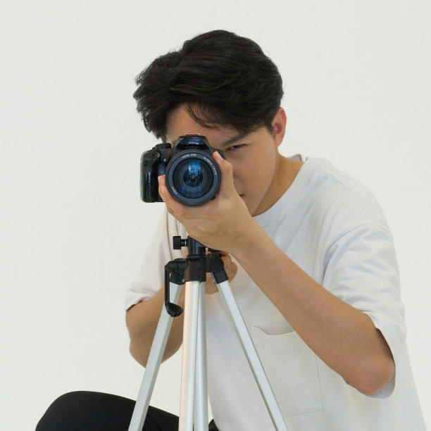 摄影师在用相机拍摄时透过取景器看。图片下载