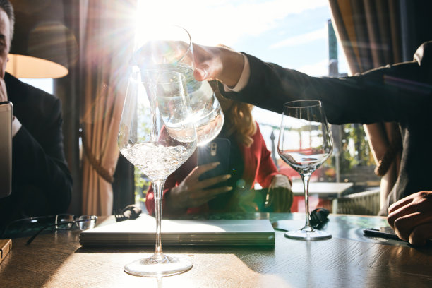 在商务会议上往酒杯里倒水的商人图片下载