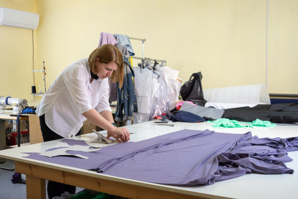 时装设计师在车间里裁剪衣服的材料细节图片下载