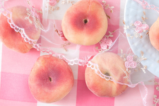 台布上摊着熟了的淡粉色桃子。甜桃背景图片下载