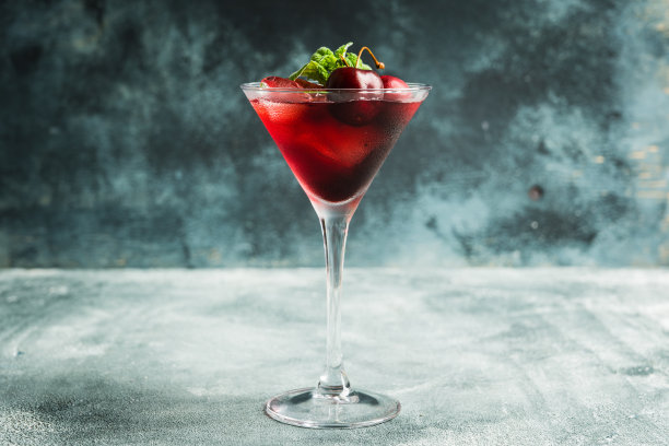 樱桃鸡尾酒在马提尼杯与浆果和薄荷叶图片下载