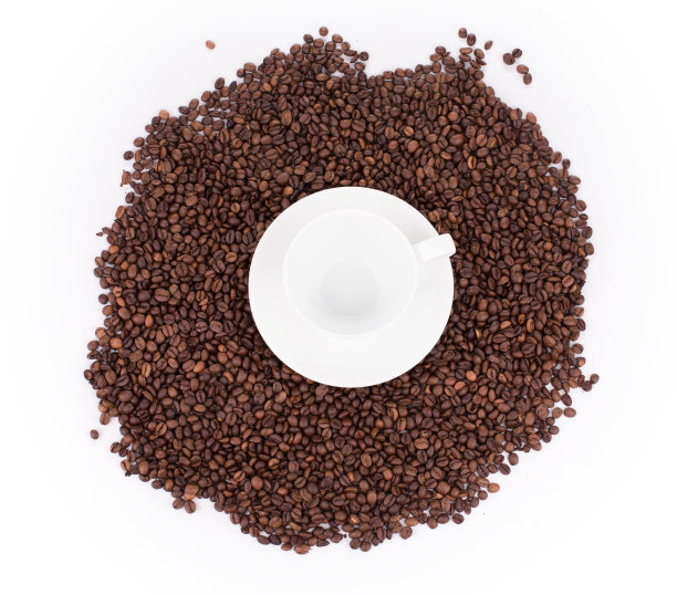 一个空的咖啡杯放在一堆烤好的咖啡豆上。图片下载