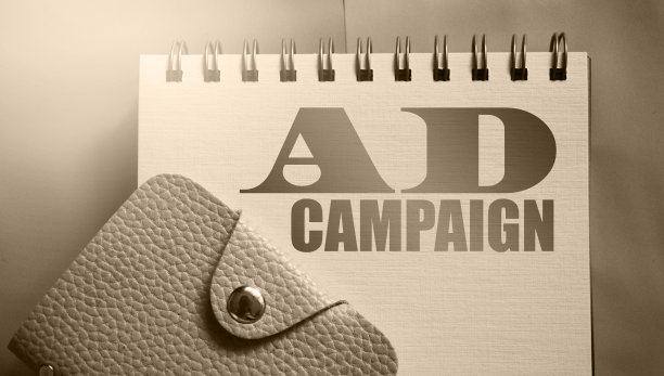 广告词在抄写页和皮革钱包。暖灰色调和选择性焦点。广告营销经营理念图片下载