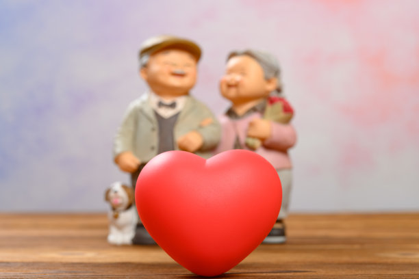 背景是一颗红心和一对微笑的老年夫妇图片下载