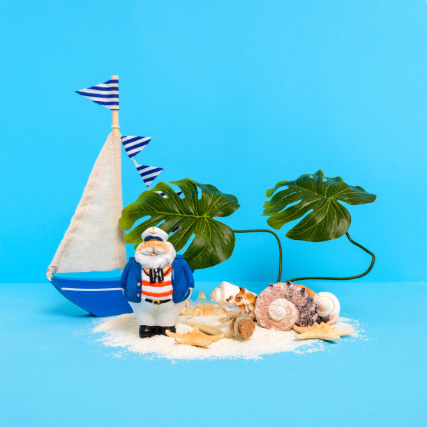 金银岛概念:沙滩上的玩具帆船和船长，还有留言瓶、贝壳、海星和怪物图片下载