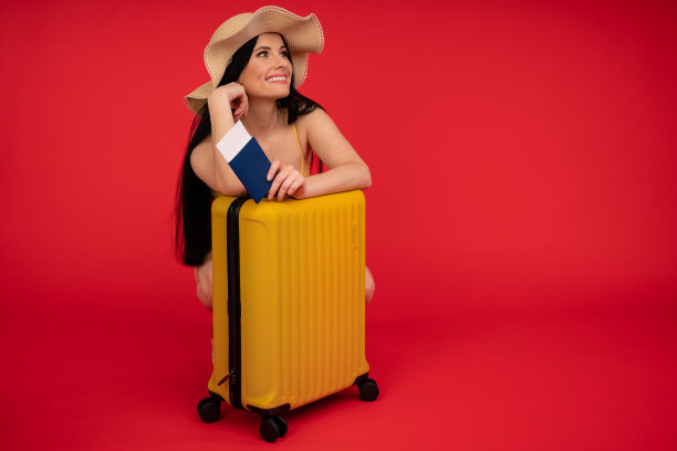 旅行的概念。一个年轻漂亮的女人拿着护照和行李。孤立的红图片下载
