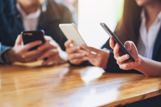 人们坐在一起使用和看手机图片下载