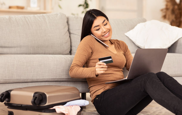 亚洲妇女在网上订票坐在家里地板上图片下载