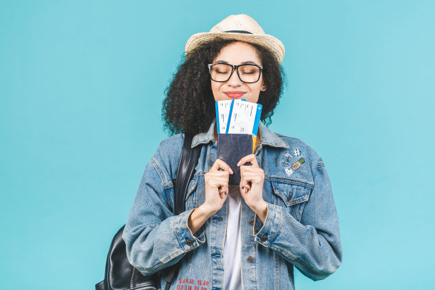 意外快乐的年轻非洲裔美国女孩孤立在蓝色背景在演播室。旅行的概念。持护照、登机牌机票。图片下载
