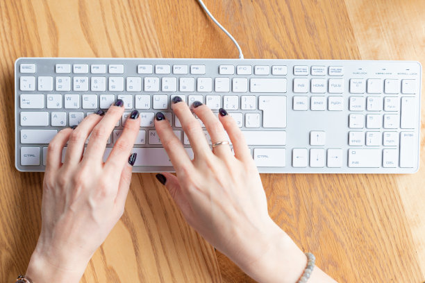 双手的商务女性与黑色美甲打字键盘在家庭办公室。距离learning.Hands,修指甲。木桌上,组织者。远程工作的地方。2019冠状病毒病大流行检疫图片下载