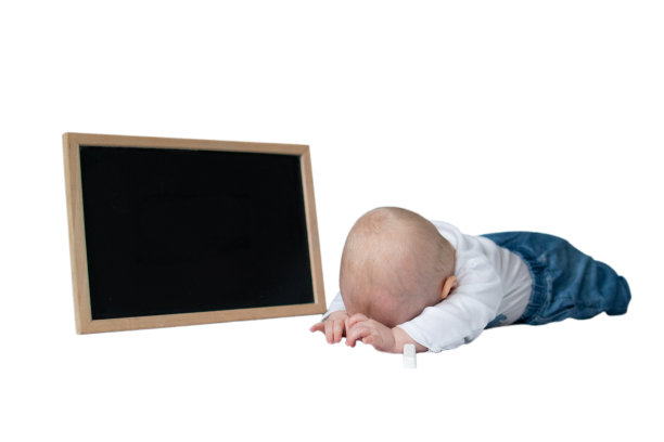 一个白人小男孩躺在地板上，头朝下用黑色的黑板写字图片下载