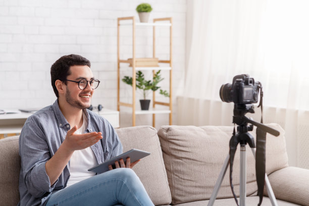 自信的年轻人用摄像机记录博客。热情地说素材图片