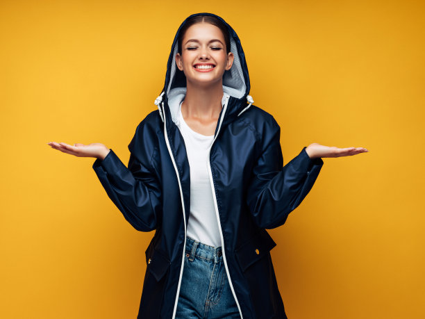 迷人的微笑年轻女子穿着雨衣图片下载