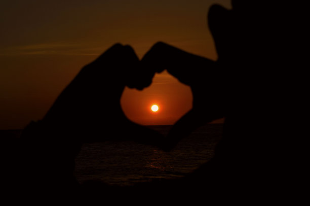 用爱的形状的手勾勒夕阳图片下载