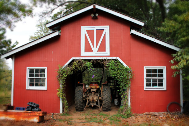 红色谷仓里的拖拉机图片下载