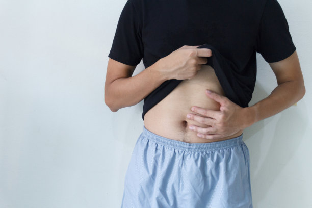 一个年轻的亚洲男人正在胃痛。图片下载