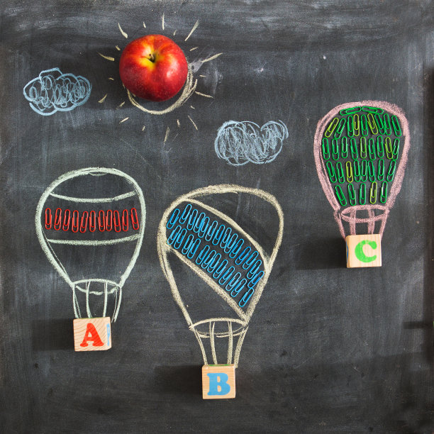 在学校的黑板上画三个气球或气球，上面写着字母ABC和学校用品。回到学校。图片下载