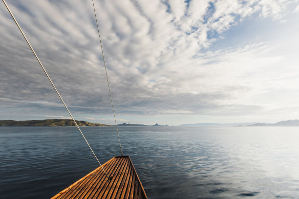 从木船上看到的田园诗般的日落海景。海的背景。游轮或游艇旅行。图片下载