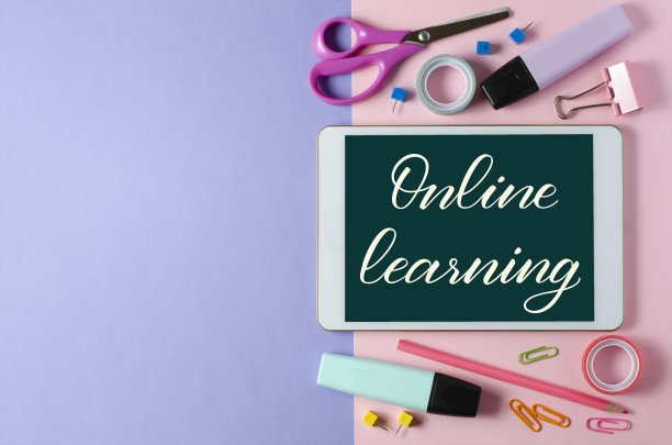 在线学习-在写字板上手写题词。对儿童进行远程训练的概念。彩色背景上的平板电脑和办公用品。本空间图片下载