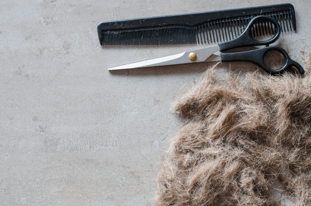 剪过的头发，剪子和梳子。理发的工具。图片下载