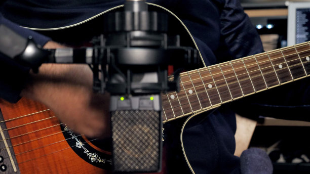 一个吉他手演奏他的原声吉他和录音图片下载