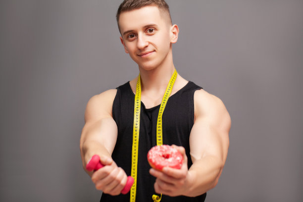 运动员拿着哑铃和甜甜圈暗示锻炼图片下载