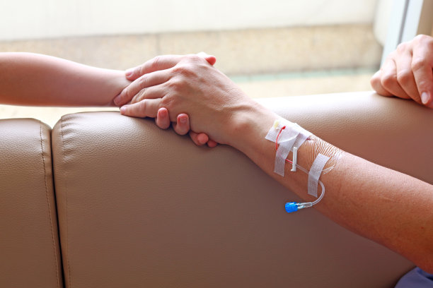患者的手臂和塑料输液器，儿童的手牵着患者的手图片下载