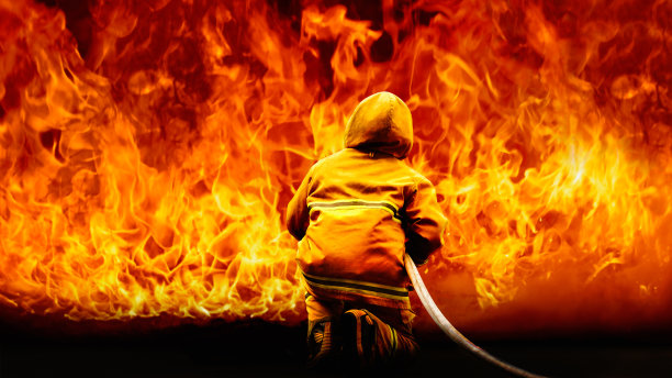 消防队员的后方，消防制服和装备在火焰背景上图片下载