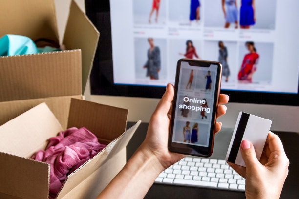 手里拿着信用卡和电话。电脑屏幕。框,键盘,鼠标。图片下载