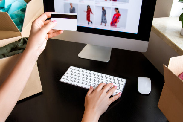 手里有信用卡。电脑屏幕。框,键盘,鼠标。图片下载