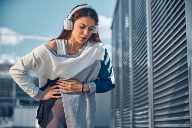 郁郁寡欢的年轻女子肚子痛得弯着腰图片下载