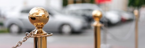 金色的玻璃装饰柱栏杆在城市街道的人行道上酒店停车场的背景图片下载