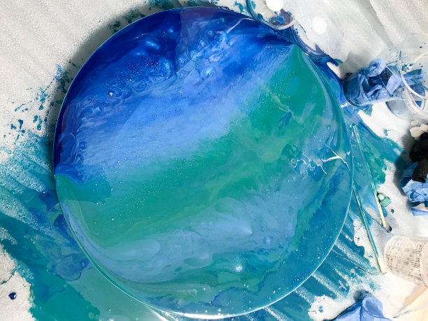 描绘海洋主题的圆形室内绘画。用流动艺术的手法，在木质背景上用环氧树脂着色。抽象的海洋与波浪的照片拍摄图片下载