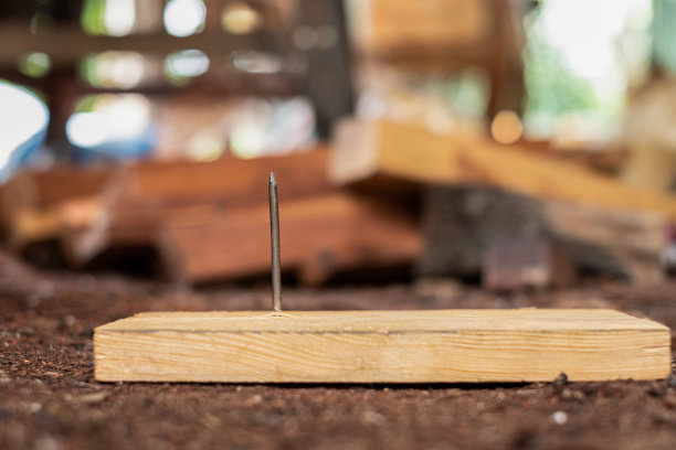 在建筑区域的木板上钉钉子图片下载