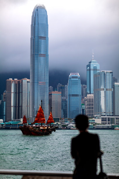 游客从九龙公众码头望着经过国际金融中心塔的帆船图片下载