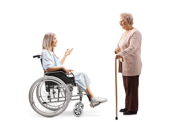 全长侧面拍摄的女性病人在轮椅上与一位老年妇女交谈图片下载