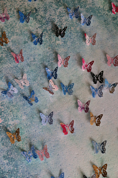 原工艺美术作品的图像裁剪出五彩缤纷的蝴蝶形状(帝王蝶-紫色，蓝色，橙色，粉红色和黑色的颜色)，彩色的艺术和工艺项目显示在墙上作为背景墙纸图片下载